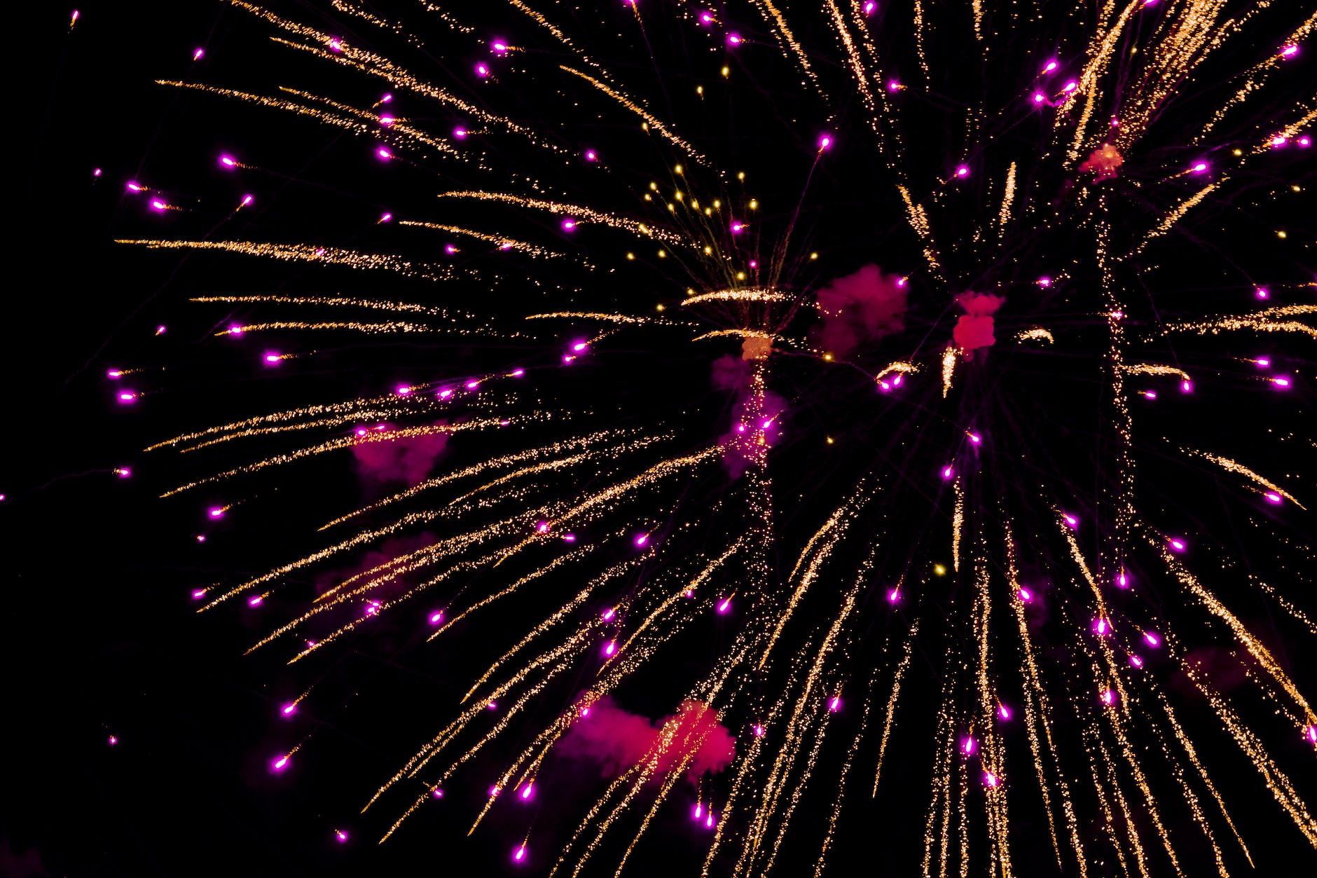 photo of purple and yellow fireworks in night sky