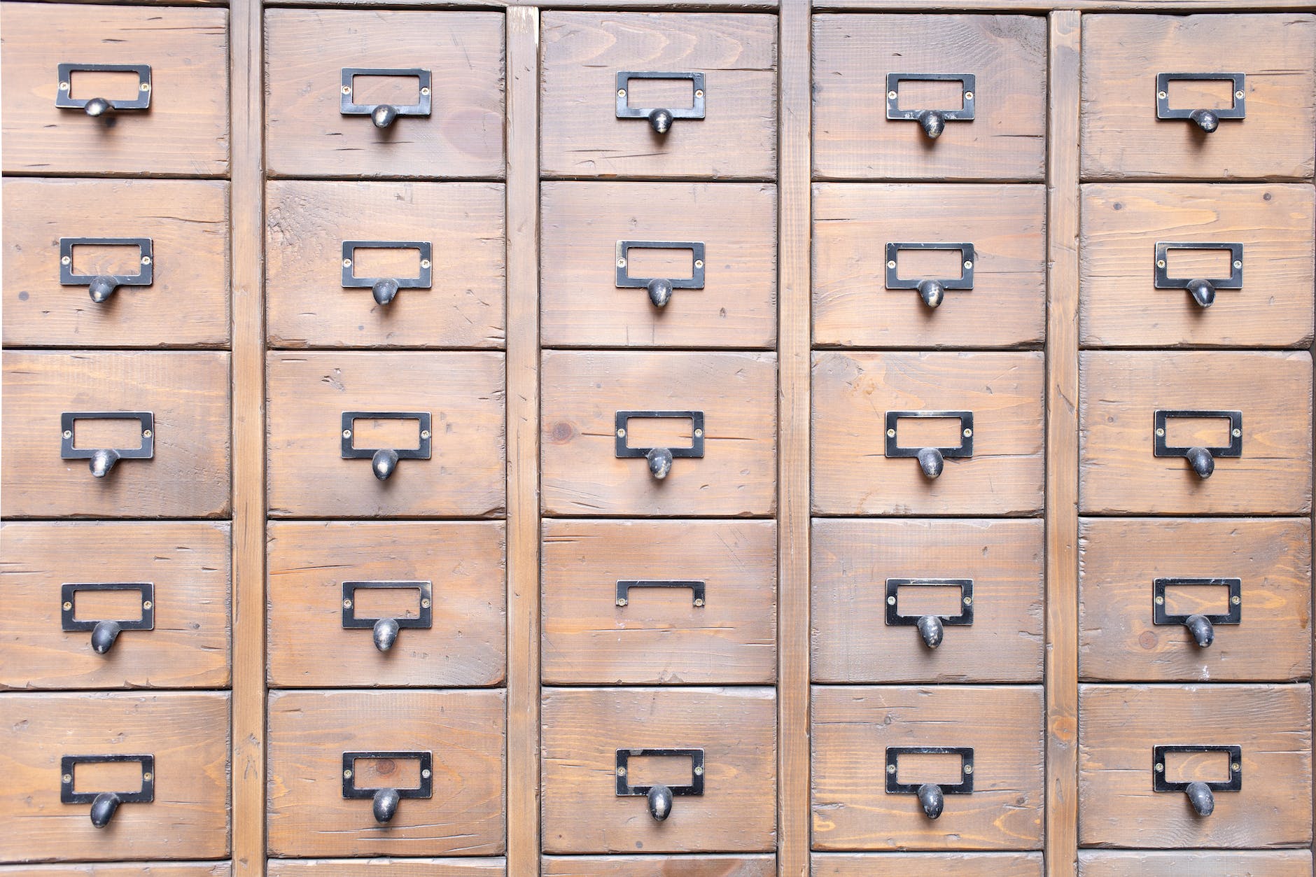 many identical wooden boxes with round handles